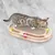 Giocattolo per gatti in legno con superficie tiragraffi e piste integrate per palline colorate. Gatto gioca attivamente con una pallina verde.
