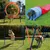 Set de agilidad para perros con aro de salto, túnel, vallas y postes de eslalon en el jardín. Muestra varios ejercicios para entrenamiento canino.