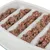 Close-up of wet food in a white feeding bowl with vertical grooves portioning the food.