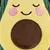 Plush toy shaped like an avocado with closed eyes, pink cheeks, and a brown pit. Yellow and green fabric with a soft texture.