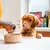 Un chien se lèche la gueule pendant qu'une personne verse de la nourriture humide d'une boîte dans une gamelle.