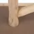 Close-up of a wooden leg with natural grain, connected to another wooden strut on a brown MDF board.