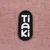Tiaki. Markenlogo auf rosa Stoffhintergrund.