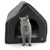 Casetta per gatti grigia con logo Tiaki, tessuto imbottito e un gatto grigio che guarda dall’ingresso.