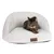 Chat allongé sur un canapé pour animaux en tissu blanc, étiquette visible avec la marque Modern Living à l’avant.