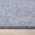 Grey felt pad on a wooden surface, close-up of material texture.