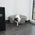 White cat with black spots leaving a grey litter box in a corner on tiled floor.