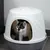 Caja de arena blanca para gatos con base gris, gato asomando por la abertura ovalada.