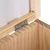Detailaufnahme eines Holzrahmens mit Metallscharnier, das eine Klappe oder Tür verbindet.