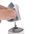 Close-up of a replaceable cutting head for an electric pet hair clipper being removed by a hand.