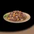Chunks of meat with orange and light yellow vegetable pieces in gravy served on a plate.