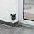 Green wall brush in corner mounting, suitable for pet grooming. Attached to a white wall next to a glass door.