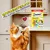 Dreamies Creamy Mega Pack x12, unwiderstehlich für Katzen und Kätzchen. Ohne Zusatz von Zucker. Katze greift nach Produkt auf Küchentheke.