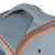 Détail d’une poignée en tissu gris avec bordure orange sur un sac ou une caisse de transport, couture visible et œillet métallique apparent.
