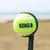 KONG tennis ball in bright yellow, attached to a black throw arm for dogs.