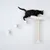 Gatto nero su gioco da arrampicata da parete bianco con colonna tiragraffi in sisal e superficie imbottita. Tre gradini conducono alla piattaforma.