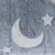 Graues, flauschiges Material mit Mond- und Sternmotiv auf weissem Hintergrund.