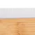 Peigne avec dents métalliques et manche en bois, vue rapprochée sur les dents alignées verticalement et la texture du bois visible.