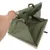 Bolsa de transporte verde con ventana de malla y cremalleras, mostrada abierta. Mano sostiene la bolsa para demostrar la función.