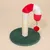 Kratzspielzeug mit grünem Teppichboden, Sisal-Kratzstange und rot-weissem Plüschbogen mit hängendem rotem Ball und Glöckchen.