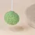Zielona piłka do zabawy z tkaniny o teksturowanej powierzchni, przymocowana do białego sznurka.