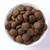 Cuenco con croquetas redondas y marrones de pienso seco. Vista del producto para mostrar la forma y el tamaño del alimento.