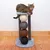 Cat tree with four sisal balls in different colours and a grey lying surface. Cat is lying on top of the surface.