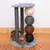 Cat tree with three sisal posts and four colourful balls made of rope material. Cat lying on the base of the cat tree.