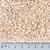 Close-up of light brown flakes with a ruler in centimetres for size reference. Flake size approximately 0 to 5 mm.