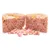 Cibo umido per animali tagliato a metà, consistenza compatta con pezzi visibili di carne rosa e gelatina superficiale, alcuni bocconcini sparsi davanti.