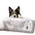 Chien allongé sur une couverture grise en tissu avec bordure en fausse fourrure, étiquette visible portant le nom TIAKI.
