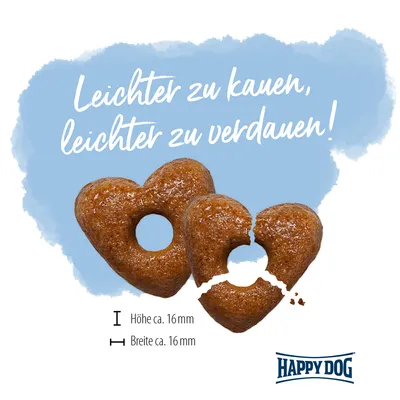 Texte en allemand : Leichter zu kauen, leichter zu verdauen ! Deux croquettes en forme de cœur, dimensions indiquées : hauteur env. 16 mm, largeur env. 16 mm. Marque Happy Dog visible.
