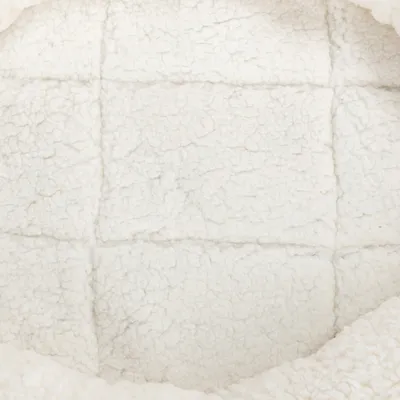 Close-up of a white, soft fabric with a textured surface, possibly for a pet bed or blanket.