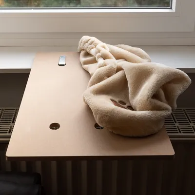 Wooden windowsill attachment with beige plush cover, suitable for pets. Two holes and metal clip visible.