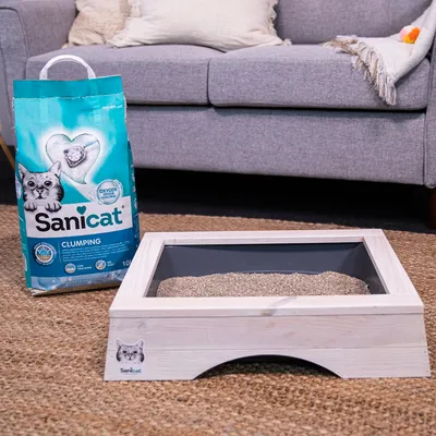 Sanicat Clumping stelivo pre mačky s Oxygen Control, 10 l vrece vedľa drevenej mačacej toalety naplnenej stelivom. Produkt pre bez zápachu a hygienické mačacie toalety.