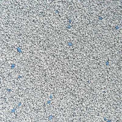 Close-up of grey granules with scattered blue pieces, showing product texture and composition for litter or absorbent material.