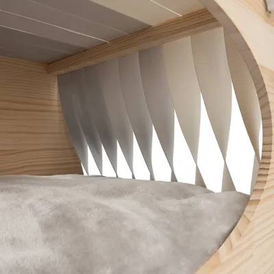 Detailansicht eines Holzrahmens mit grauem Stoffpolster und flexiblen weissen Lamellen, geeignet für Möbel oder Tierzubehör.