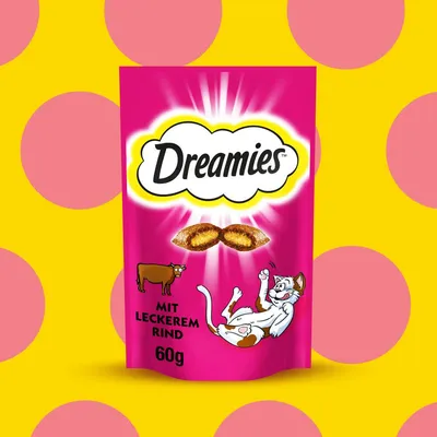 Dreamies, mit leckerem Rind, 60g. Envase rosa con ilustración de vaca y gato, dos snacks visibles en el centro. Texto en alemán.