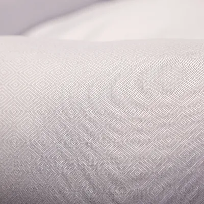 Gros plan sur un tissu gris clair avec motif géométrique de petits losanges.