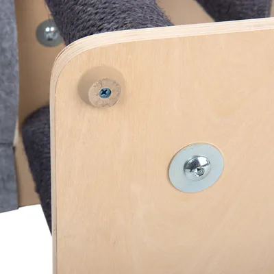 Træplade med gråt stof og synlig metalfastgørelse. Nærbillede af et møbel eller tilbehør.