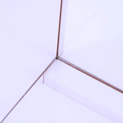 Detailaufnahme einer Ecke aus transparentem Glas mit Metallrahmen, zeigt präzise Verarbeitung und klare Linien.