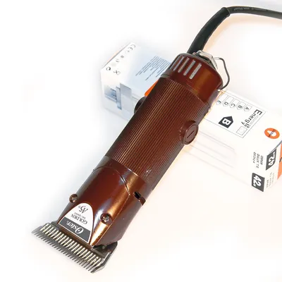 Tondeuse électrique marron Oster Golden A5, câble noir, posée sur une boîte blanche avec étiquette énergie classe B et texte partiellement lisible.