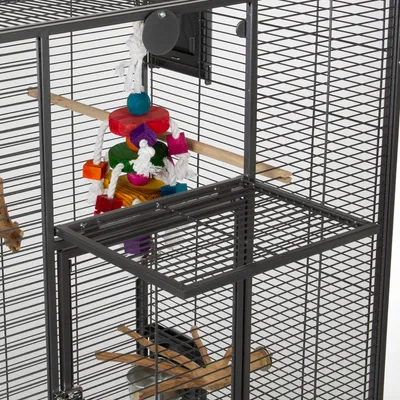 Vogelkooi van metaal met houten zitstok, kleurrijk touwspeelgoed en voederbak zichtbaar aan de binnenkant.