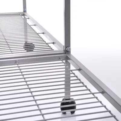 Dettaglio di ripiani in metallo con griglia e ruote, struttura fissata con bulloni visibili.