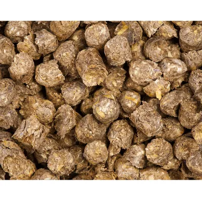 Close-up of compressed brown feed pellets with visible plant fibres and grains, showing texture and ingredients for assessing product quality.