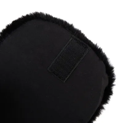 Close-up van een zwart, pluizig materiaal met klittenbandsluiting. Detailweergave van het product.