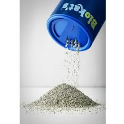 Areia para gatos a ser vertida de um recipiente azul com a marca Biokat's visível. O granulado forma um monte sobre uma superfície branca.