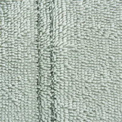 Detaliu material textil tip microfibră, culoare deschisă, cu fire dense și textură moale, vizibilă în prim-plan.