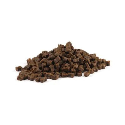 Hoopje kleine, bruine brokjes of snacks zonder zichtbare verpakking of merknaam, geschikt als honden- of kattensnack. Materiaal: onbekend, alleen het product is zichtbaar.