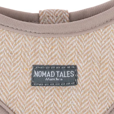 Nomad Tales München. Nærbillede af beige-mønstret stof med mærketikette.